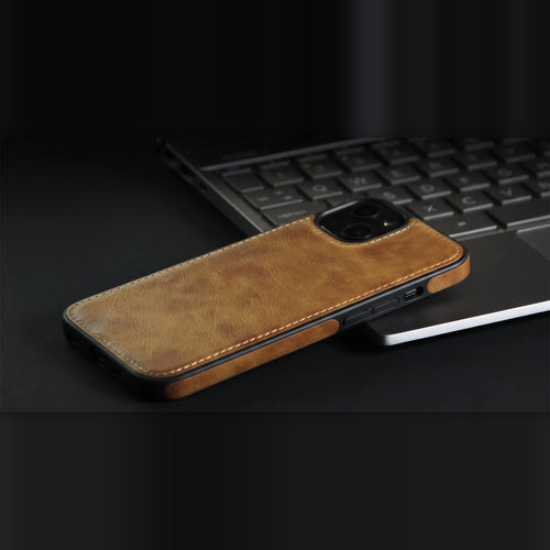 Slim vegan leather iPhone case in brown, resting on a laptop, showing how thin it is